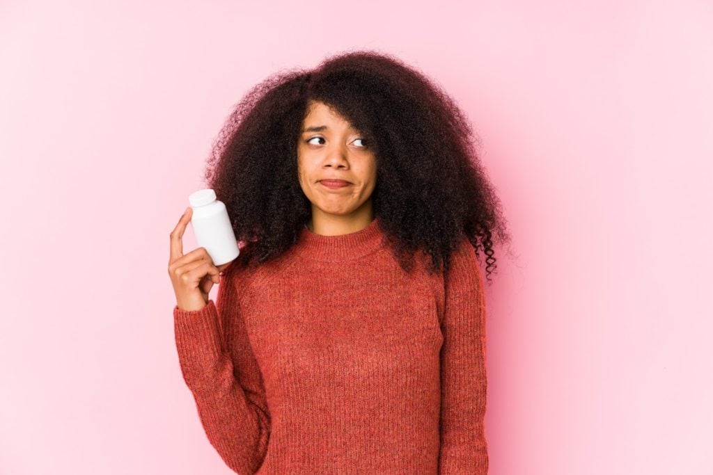How long can you go without thyroid medication: Woman holding prescription bottle with uncertain expression