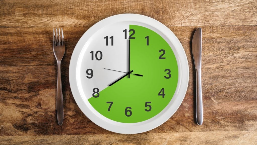 Bone broth fast: a clock with a knife and fork in the table