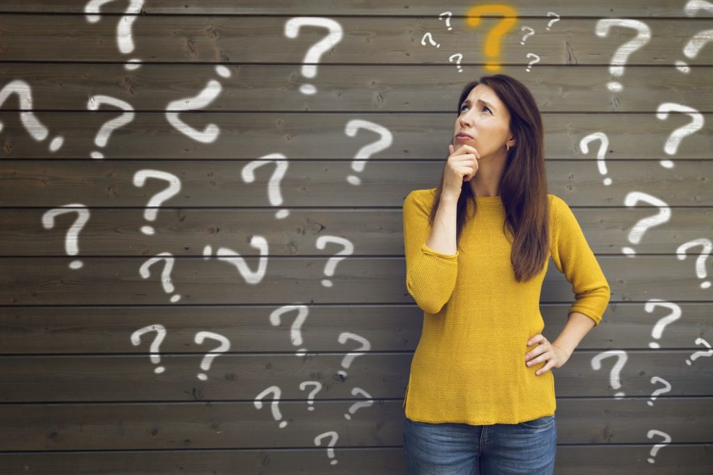 food allergy testing kit: Woman in a thoughtful pose surrounded by question marks