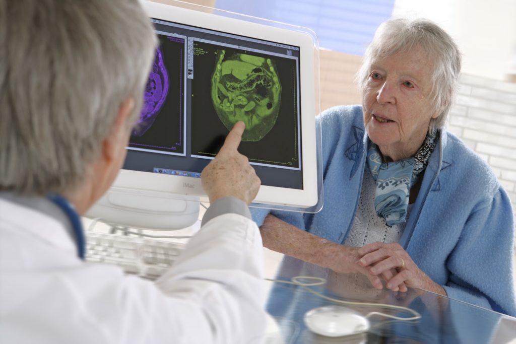 Elderly woman looking at her doctor while he explains her lab results
