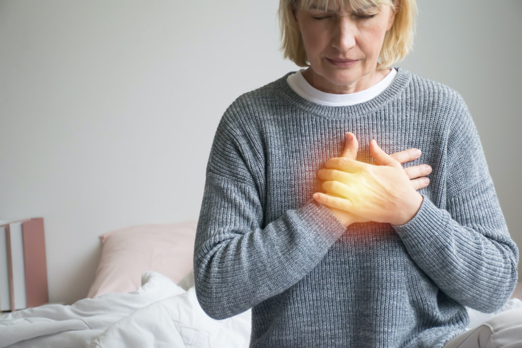 silent reflux: Woman holding her chest with her two hands