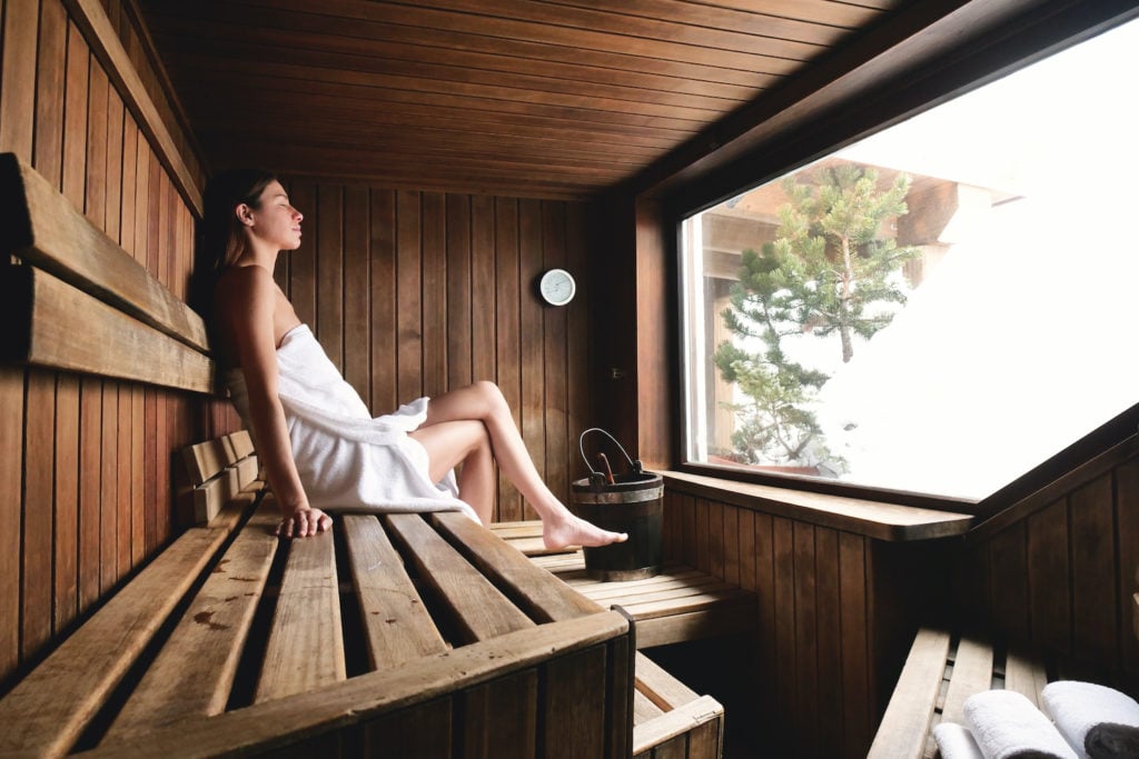 sauna therapy: Woman with a towel wrapped around her body in a sauna