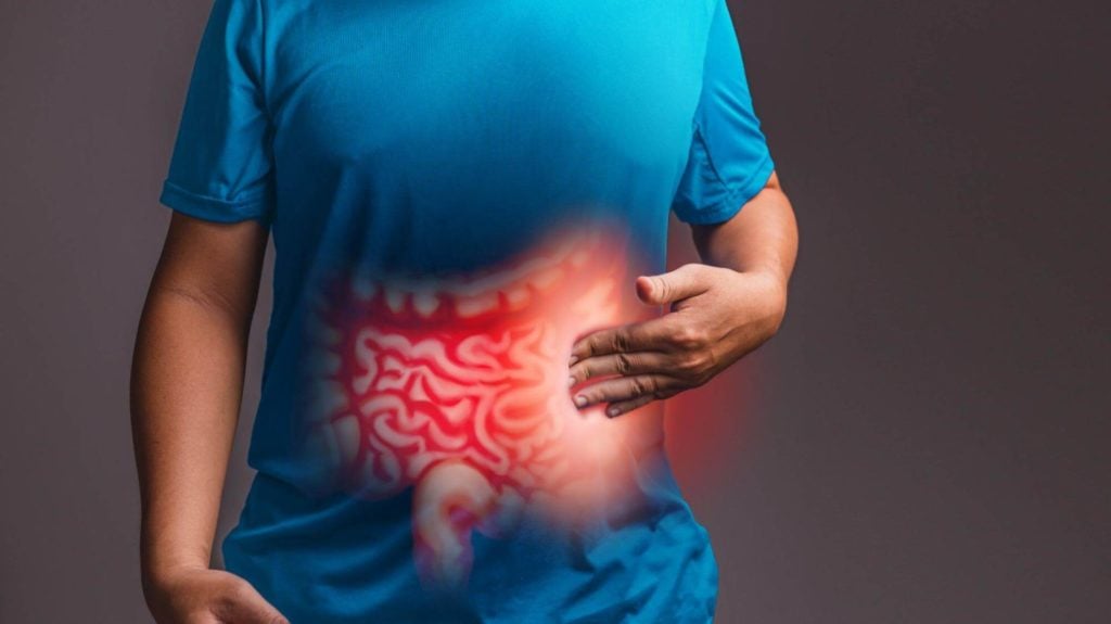 Man touching his stomach with a 3D illustration of intestines over it