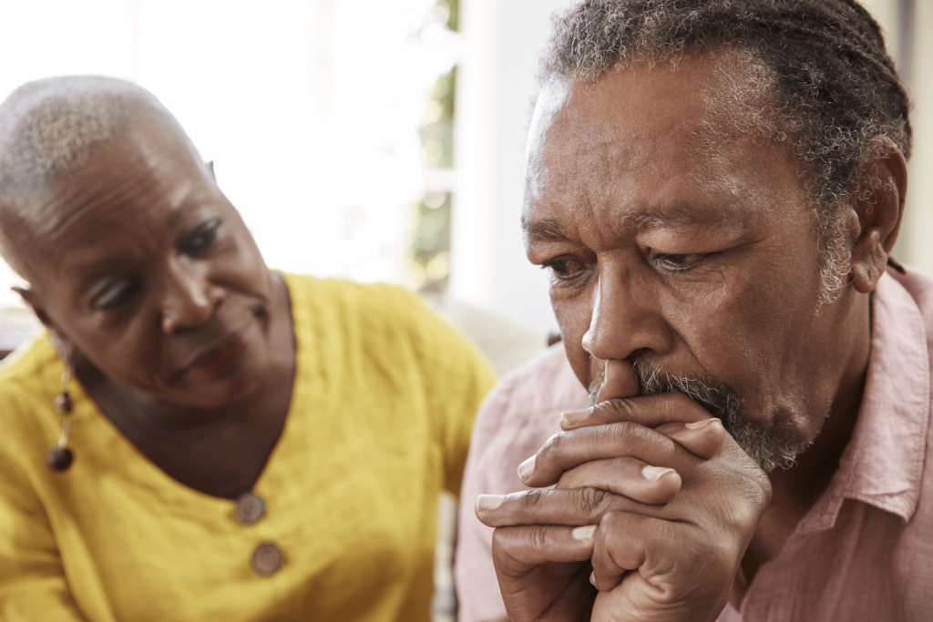 early signs of dementia checklist: Elderly woman comforting a sad elderly man