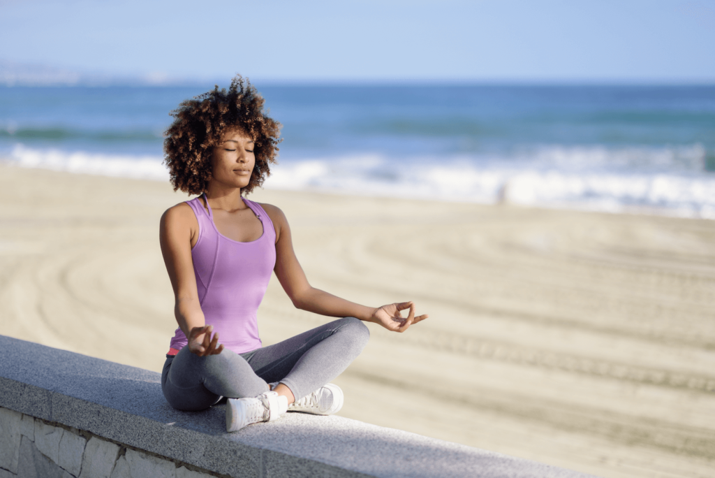 Woman meditating while at the beach