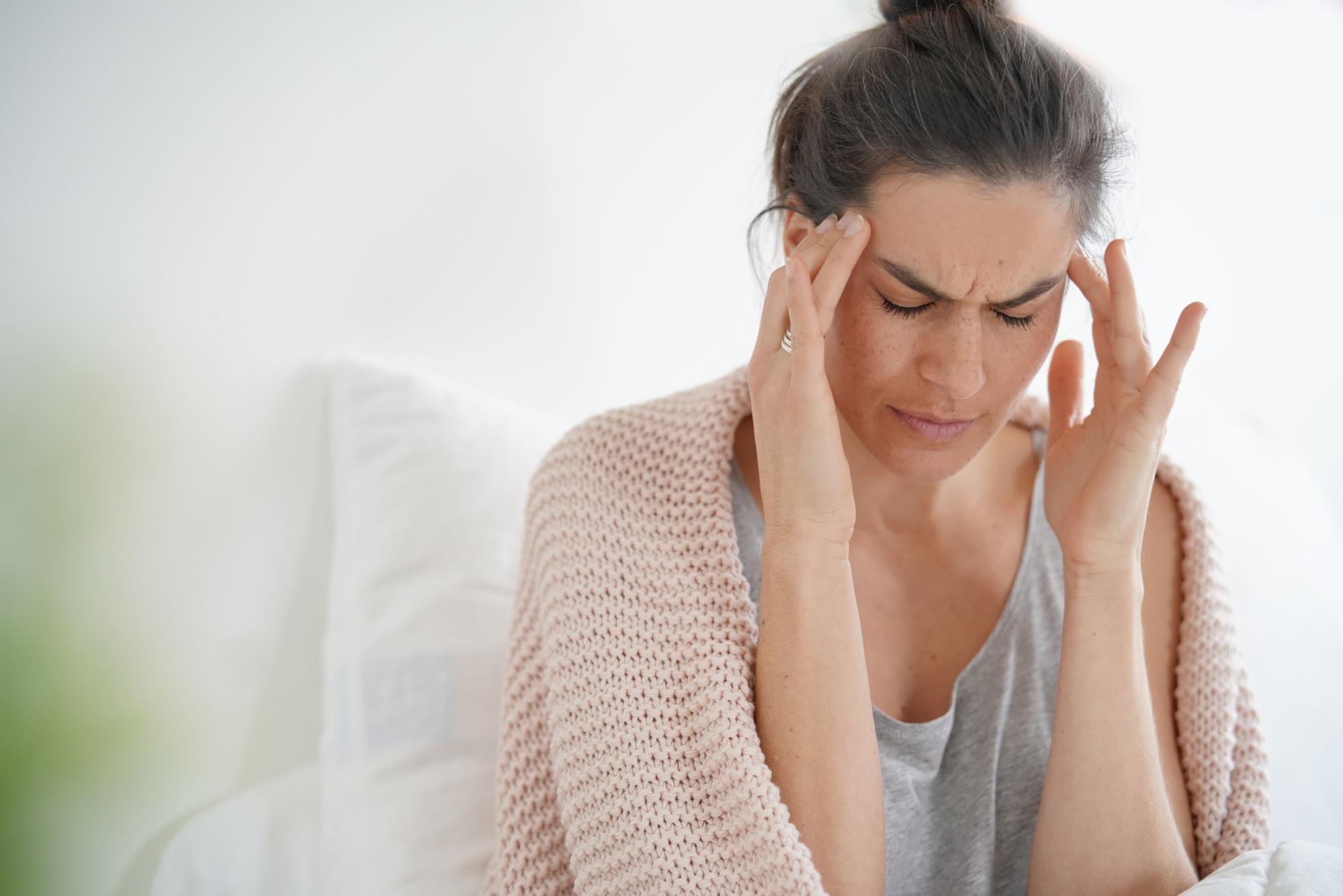 adrenal fatigue symptoms: Woman holding her head in pain