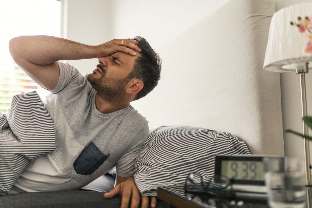 How to prevent a hangover: man waking up with a headache