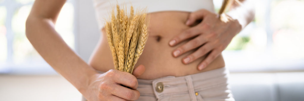 Person holding some wheat near their stomach