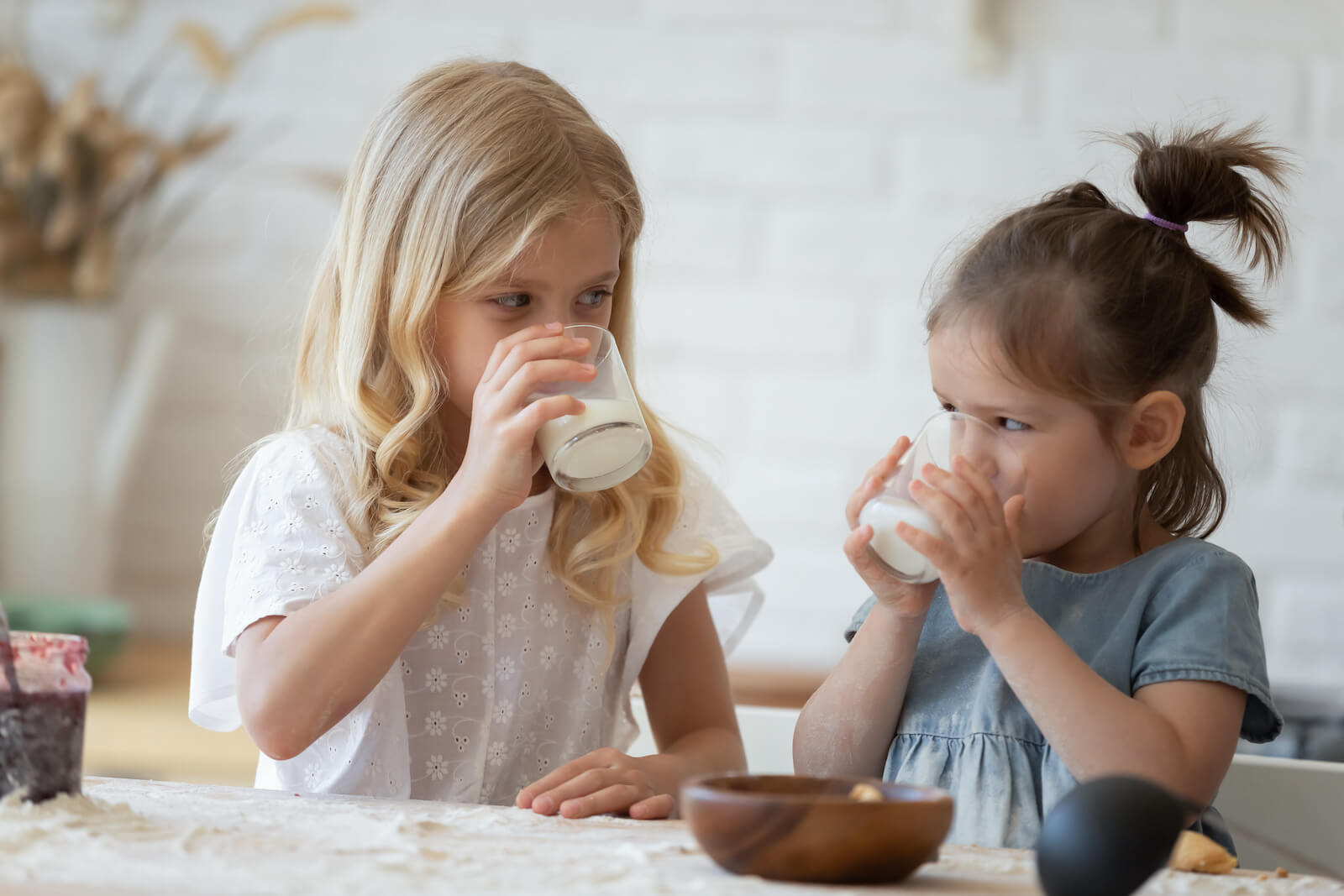 Two little girls drinking milk