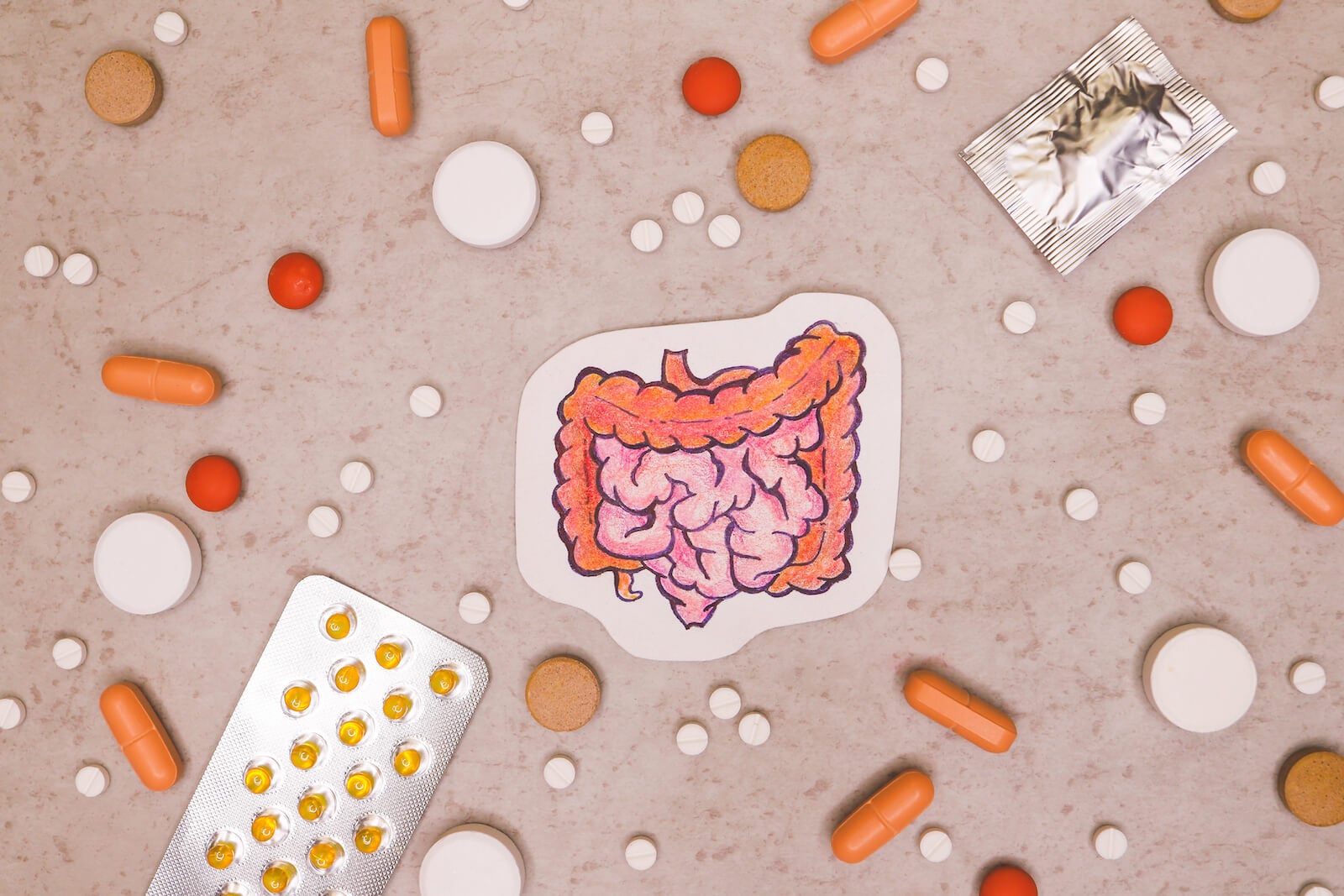 Drawing of an intestine surrounded by various pills