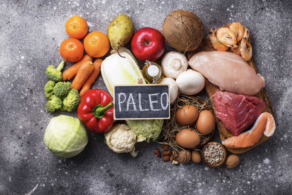 Crohns disease treatment: Paleo written on a small blackboard on top of various food ingredients