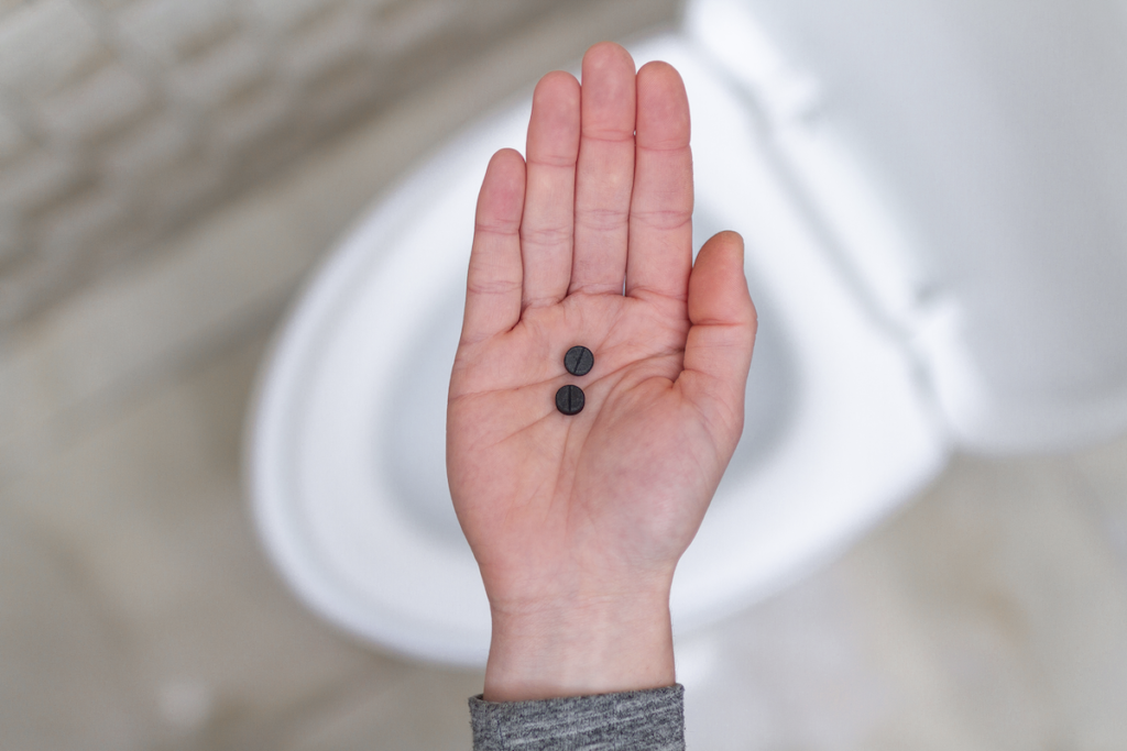 Person with two black tablets on their palm