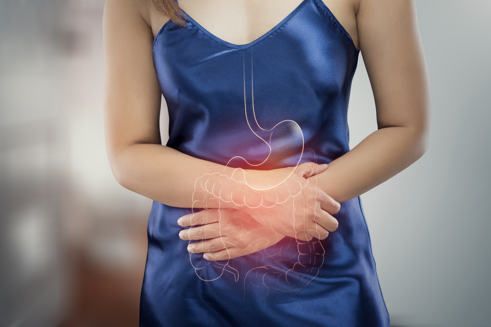 colon pain: Illustration of the large intestine against an image of a woman clutching her stomach in pain