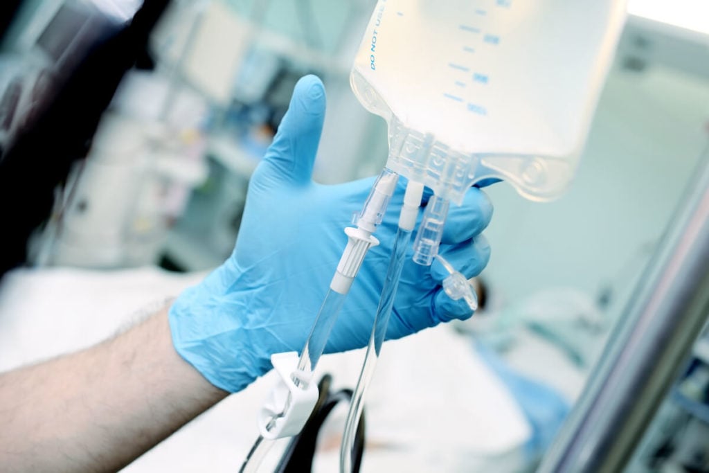 IV vitamin therapy: person adjusting an IV