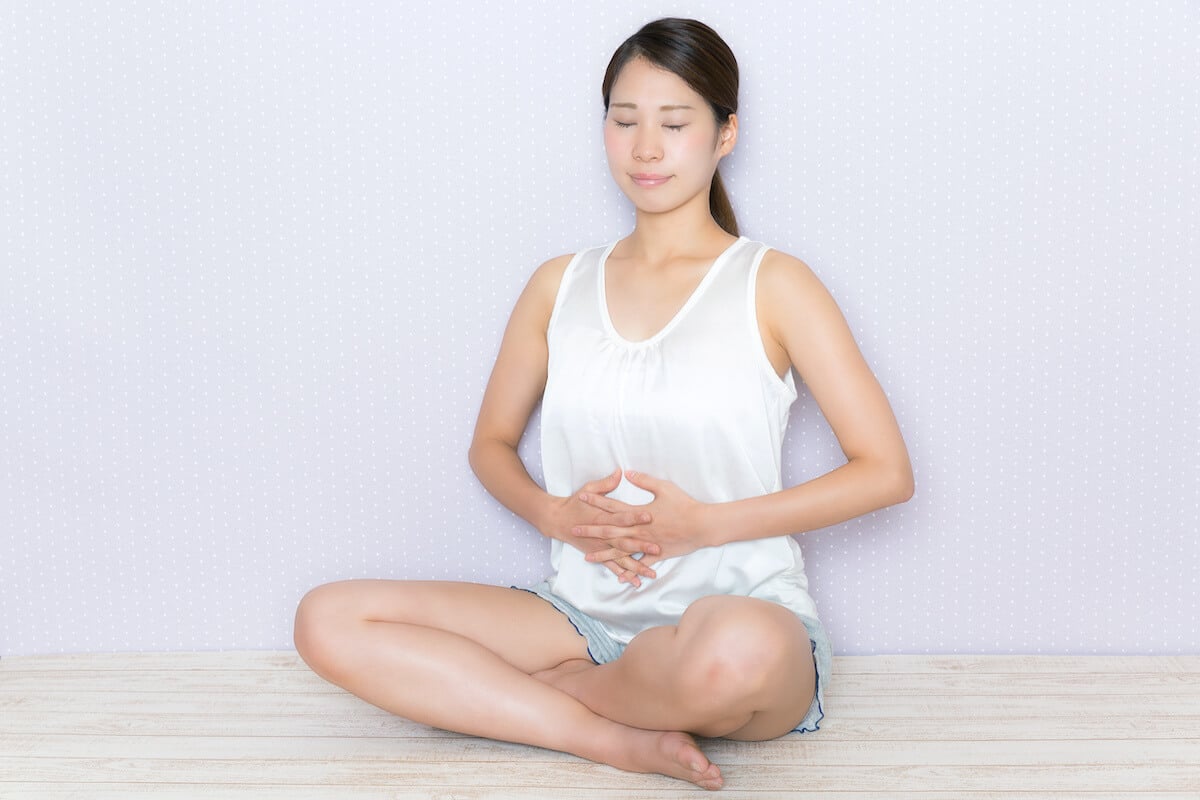 Meditation for IBS: woman touching her stomach