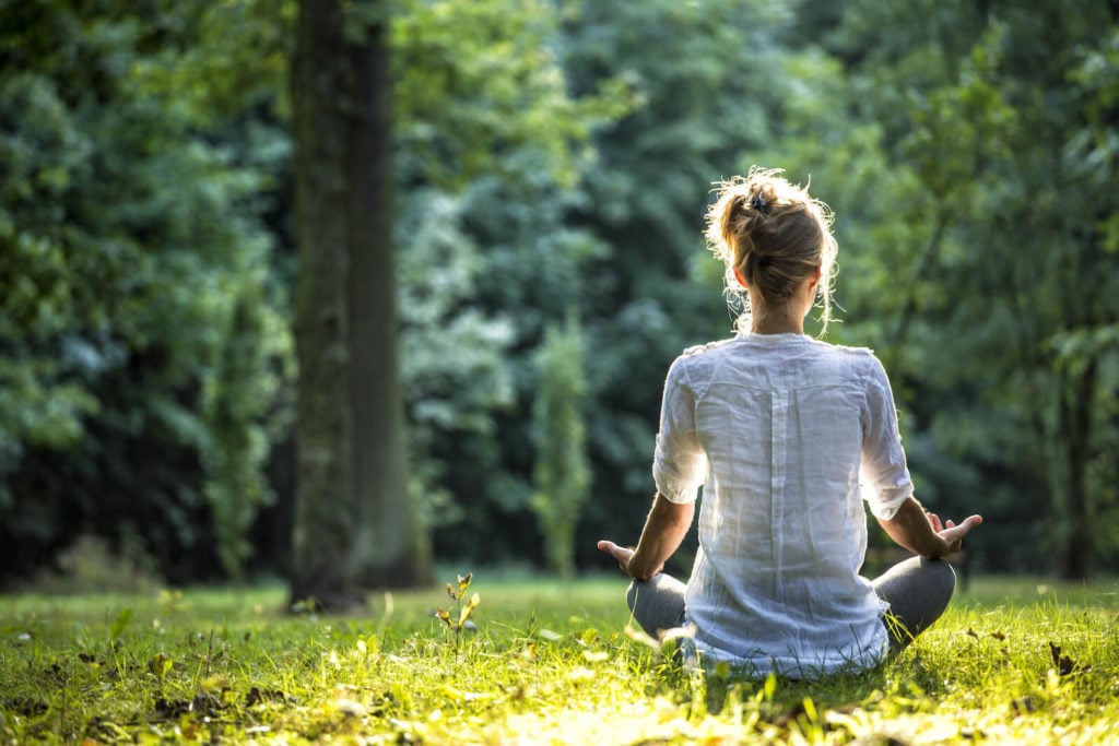 Woman meditating in a forest